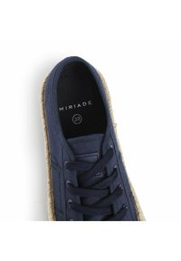 Scarpa in tela blu marina con suola in espadrille intrecciata e texturizzata. Presenta un design con lacci e un'etichetta interna che dice "MIRIADA 38."