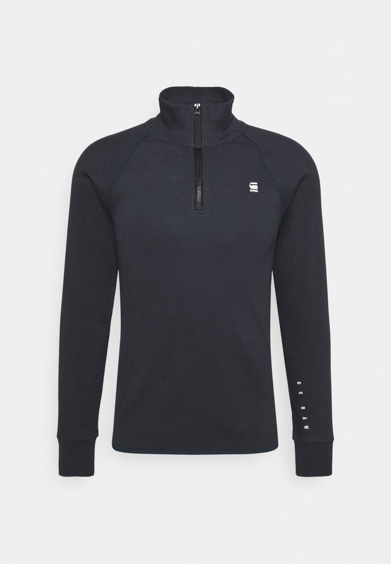 Marinblå fleecepullover med hög krage och halvdragkedja. Har långa raglanärmar och diskret logotyp på bröstet och ärmen.