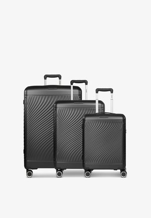 Drie zwarte harde koffers in verschillende maten, met een golvende textuur, telescopische handgrepen en vier wielen voor mobiliteit.