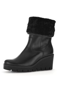 Botte de cheville en cuir noir avec une bordure en fausse fourrure, semelle compensée et semelle texturée. Fini lisse et design à bout rond.