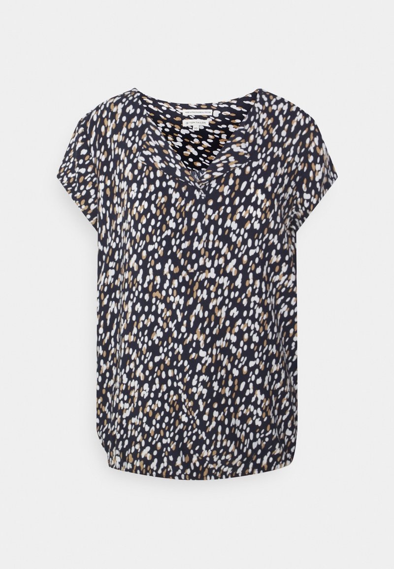 Blouse noire à manches courtes avec un motif abstrait de points blancs et bruns et un décolleté en V.
