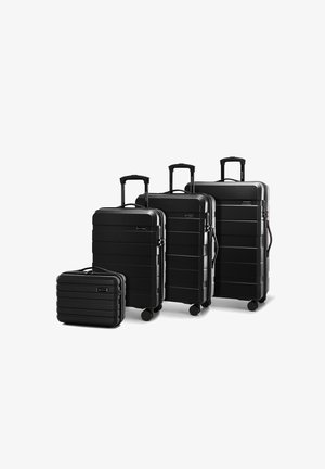 Quattro valigie rigide nere di diverse dimensioni, con un design rigato, manici allungabili e ruote per il trasporto.