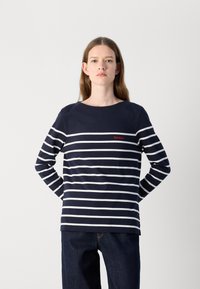 Tume sinise värvi pikkade varrukatega T-särk, millel on valged horisontaalsed triibud ja punane "Barbour" logo. Laisk sobivus, ümar kaelus, puuvillane materjal, sile tekstuur.