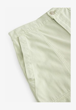 Pantaloni corti plissettati di colore verde chiaro realizzati in un tessuto testurizzato. Presentano una chiusura con bottone e dettagli di cucitura visibili lungo la vita e le cuciture.