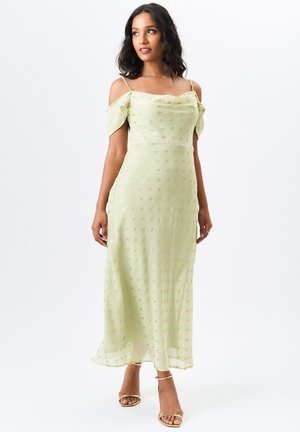 Light green, off-the-shoulder dress with a flowing design, gold dot patterns throughout, and thin spaghetti straps. Smooth, lightweight fabric.