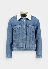 Jeansjacka med en ljusblå tvätt, fårskinnskrage, två bröstfickor och silverknappar. Har en figurnära passform och sömdetaljer.