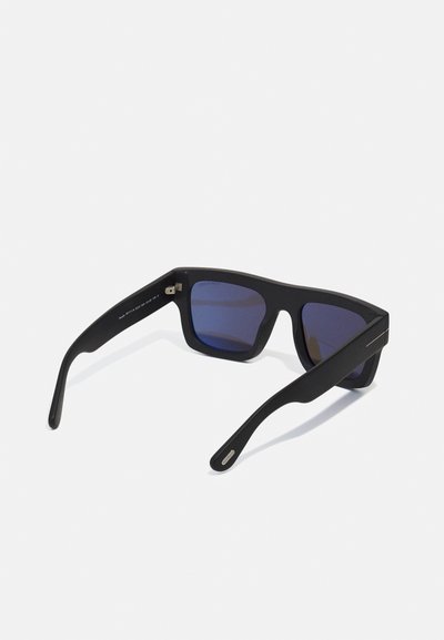Lunettes de soleil noires avec une finition mate, montures rectangulaires, verres teintés en bleu, et un accent argenté sur les tempes. Design léger.