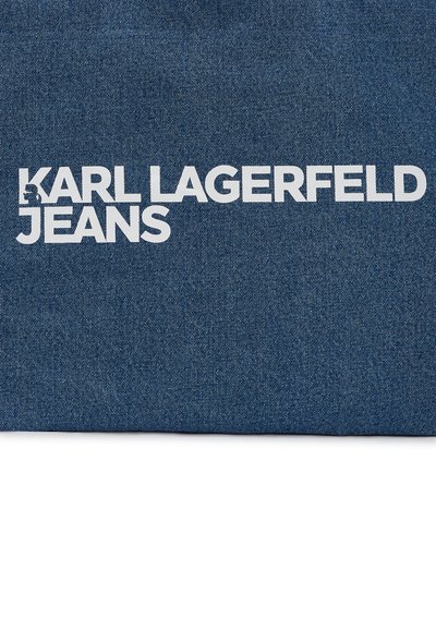 Tissu en denim bleu foncé ; présente un grand texte blanc "KARL LAGERFELD JEANS" bien en vue. Texture lisse, design décontracté.