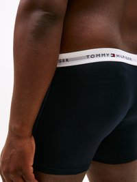 Boxer in cotone nero con una fascia elastica bianca con il marchio "TOMMY HILFIGER". Texture liscia con un design aderente.