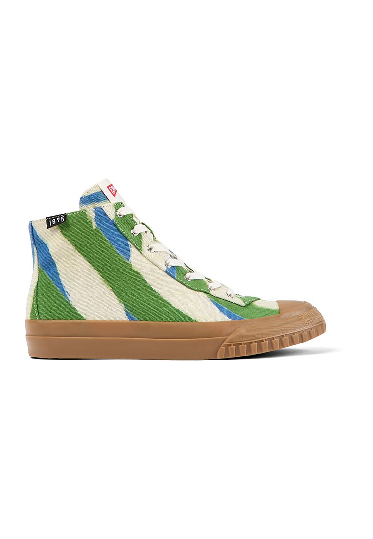 Hochformat Sneaker mit einem Obermaterial aus grünem, blauem und beigem Canvas, weißen Schnürsenkeln, brauner Gummisohle und einem "1975"-Label nahe dem Kragen.