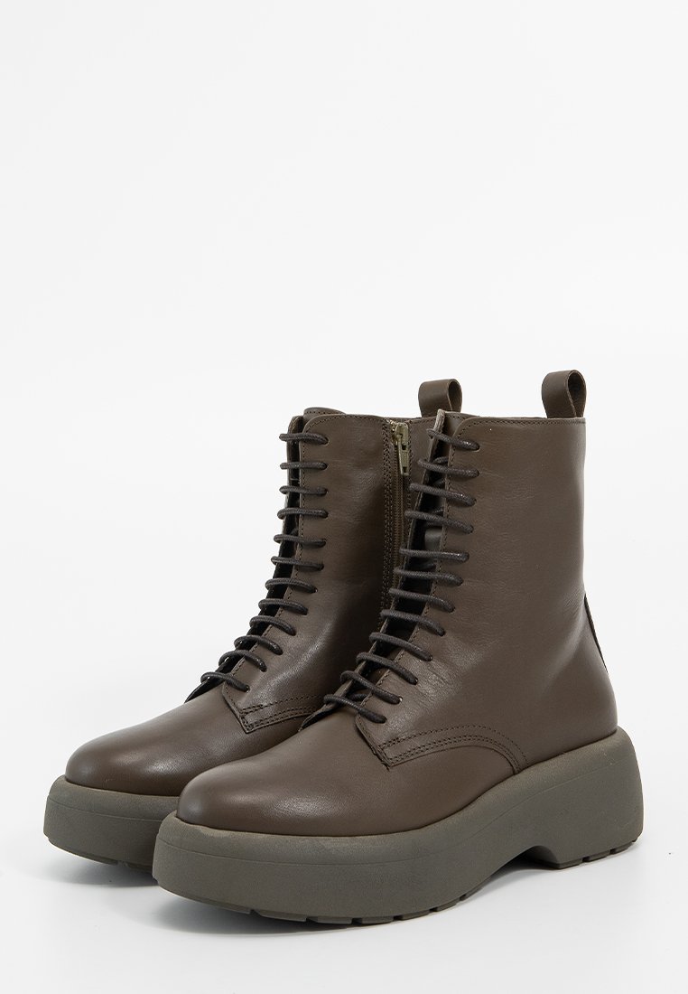 Brązowe skórzane botki za kostkę z sznurówkami i bocznym zamkiem błyskawicznym oraz grubą szaro-skalną platformą na białym tle.