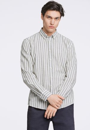 Button-up shirt in light green and white stripes, made of soft fabric. Features a collar and buttons, with long sleeves and a relaxed fit.