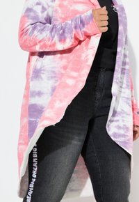 Cardigan largo y de frente abierto con un patrón de tie-dye en tonos rosa, púrpura y blanco, confeccionado en una tela suave y con un diseño fluido.