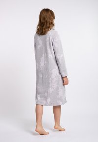 Accappatoio grigio chiaro realizzato in un tessuto morbido con un motivo floreale in rosa pallido. Presenta maniche lunghe e un taglio fino al ginocchio, progettato per il comfort.
