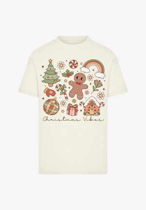 Cream t-shirt featuring festive graphics: gingerbread man, Christmas tree, candy canes, gifts, and "Christmas Vibes" text in a playful font.
