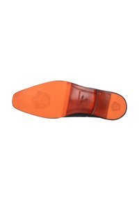 Suela de un zapato de vestir de cuero negro con puntera y talón de cuero naranja, que presenta logotipos en relieve y clavos metálicos en el talón.