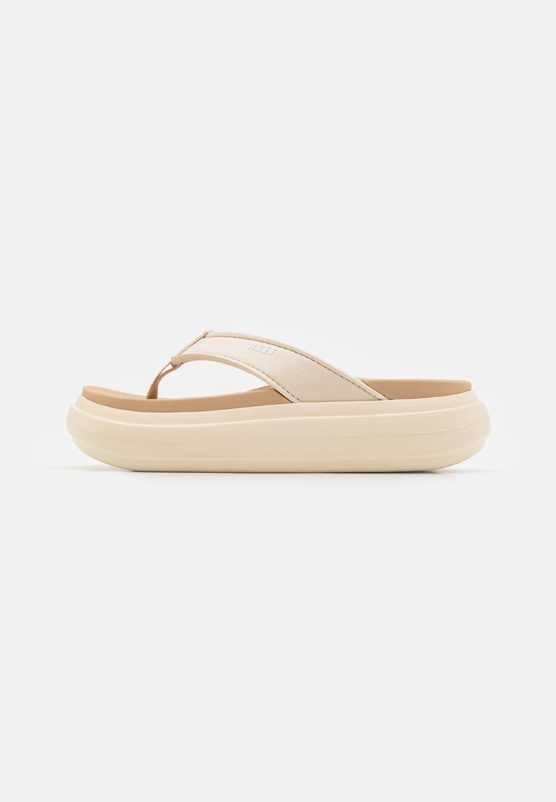 Beige flip-flop sandal with a wide toe strap and a thick, rounded sole. Features a smooth upper material and a contrasting brown footbed.