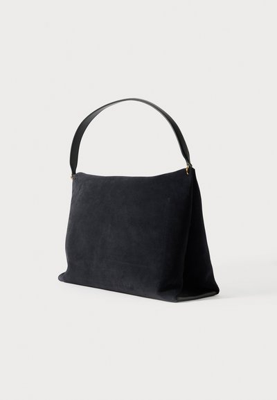 Tumši zila zamšādas plecu soma ar melnu ādas rokturi, taisnstūra forma un gluda tekstūra, ar minimālistisku dizainu un bez redzamas aparatūras.