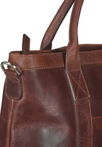 Braune Lederhandtasche mit strukturiertem Finish, ausgestattet mit doppelten Griffen, einem gesteppten Band und einem metallischen Hardware-Detail an der Seite.