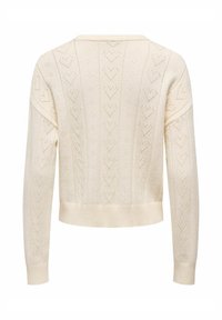 Pull couleur crème avec un design texturé comprenant des motifs en forme de cœur, des poignets côtelés et un ourlet court. Fabriqué en maille douce.