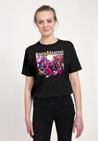 Černé bavlněné tričko s barevným grafickým potiskem animovaných postav Power Rangers. Klasický kulatý výstřih a volný střih.