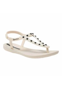 Infradito in gomma beige con borchie nere, dotati di design a T e strap sul tallone per supporto. Suola interna testurizzata per il comfort.