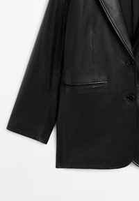 Zwarte leren blazer met een inkeping aan de revers, sluiting met één knoop en twee voorzakken. Kenmerkt zich door een gladde textuur en een getailleerde pasvorm.