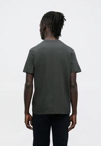 Ciemnoszary t-shirt z krótkim rękawem i okrągłym dekoltem, wykonany z gładkiej, lekkiej tkaniny, prezentujący prosty, czysty design bez widocznych wzorów.