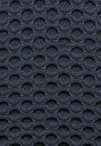 Tejido texturizado en azul marino oscuro con un patrón de panal, que muestra formas circulares elevadas y una apariencia tejida. Diseño limpio y estructurado.