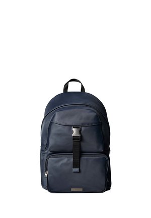 Navy blue backpack with top handle, front pocket secured by metal buckle and zipper, and padded main compartment.