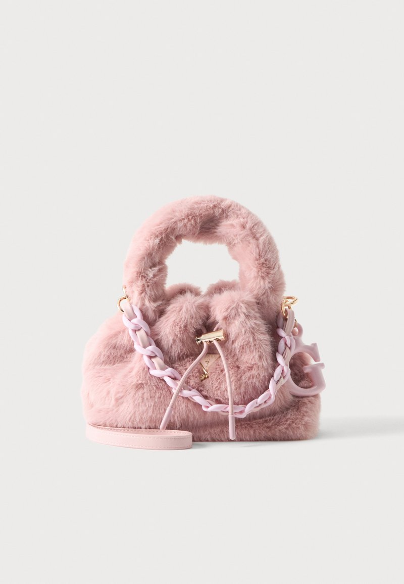 Sac à main rose duveteux avec poignée ronde, bandoulière en chaîne tressée, fermeture à cordon et petit pendentif logo attaché sur fond uni.