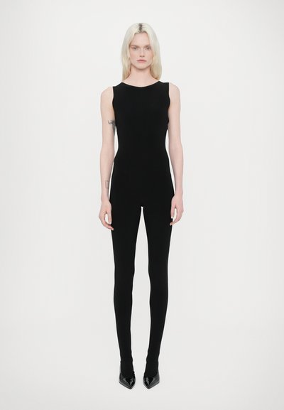 Completo senza maniche nero con un design aderente, dalla texture liscia e gambe lunghe, abbinato a tacchi a punta neri.