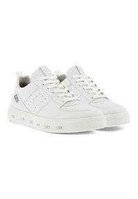 Sneaker bianche realizzate in pelle liscia, con un design perforato sui lati, lacci bianchi piatti e una suola ammortizzata con dettagli circolari.