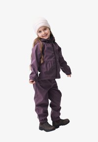 Ensemble de vêtements de pluie violet comprenant une veste et un pantalon avec des poignets élastiques, associé à un bonnet en tricot crème et des bottes marron. Texture lisse et design pratique.