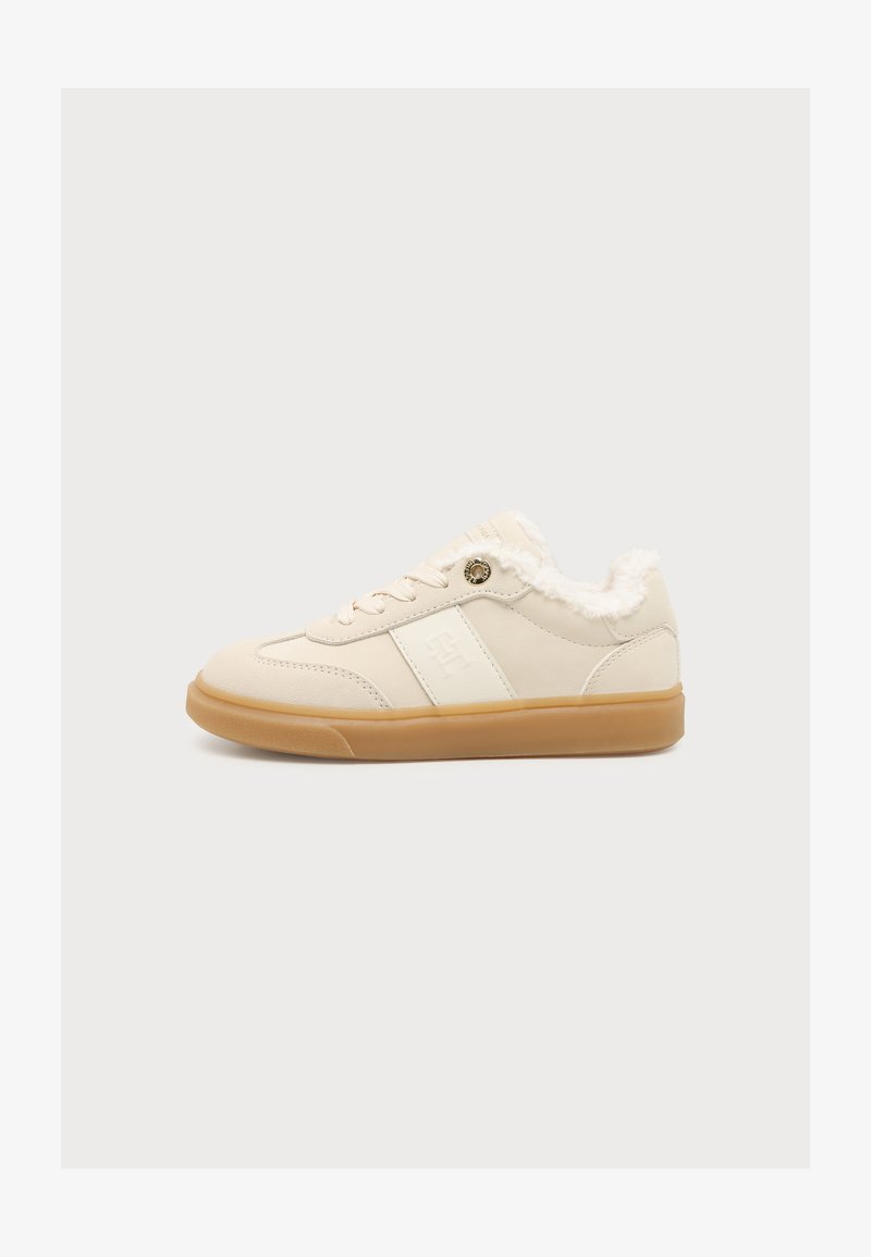 Μπεζ χαμηλό sneaker με λαστιχένια σόλα, κορδόνια μπροστά, λευκή πλευρική ρίγα και αφράτη λευκή επένδυση γύρω από το γιακά.