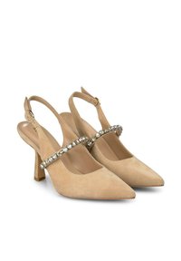 Beżowe zamszowe buty na słupku z wydłużonym czubkiem, cienkim obcasem oraz dekoracyjnym paskiem z przezroczystymi kamieniami na wierzchu.