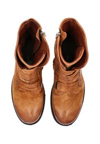 Stivali alla caviglia in pelle marrone con finitura testurizzata, design a sovrapposizione, cerniere laterali e cinturini sovrapposti sulla parte superiore. Suole in gomma piatta.