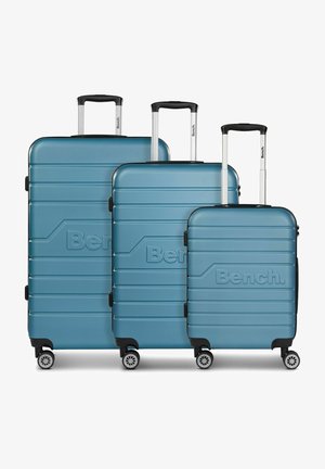 Drie lichtgewicht turquoise harde koffers in verschillende maten, met horizontale ribbels, zwarte accenten en multidirectionele wielen.