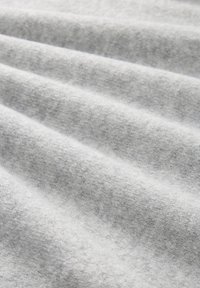 Tissu gris à surface douce et texturée, présentant des ondulations légères et une couleur raffinée et uniforme. Léger et polyvalent dans son design.