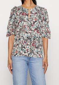 Blusa a maniche corte con stampa paisley multicolore, caratterizzata da un collo rotondo e dettaglio a chiave, realizzata in tessuto leggero.