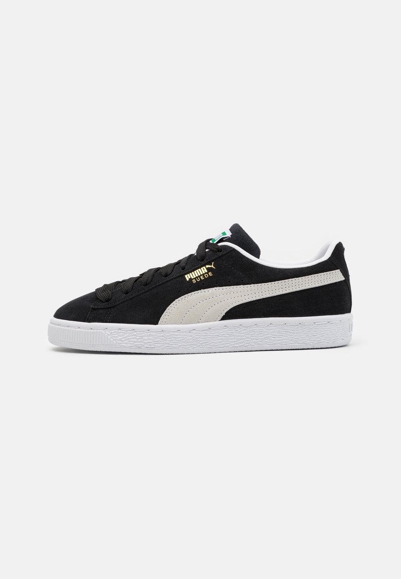 Baskets Puma en daim noir avec bande blanche, semelle blanche et lacets noirs, vues de côté sur fond uni.