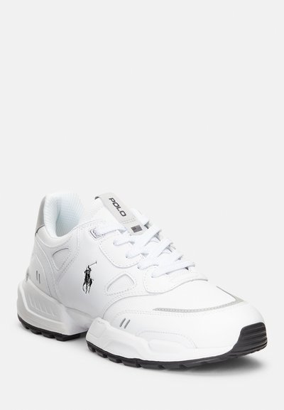 Zapatillas deportivas blancas con material sintético suave, detalles de malla, diseño de cordones, perforaciones laterales y una suela de goma negra. Logo de Polo en la parte destacada.