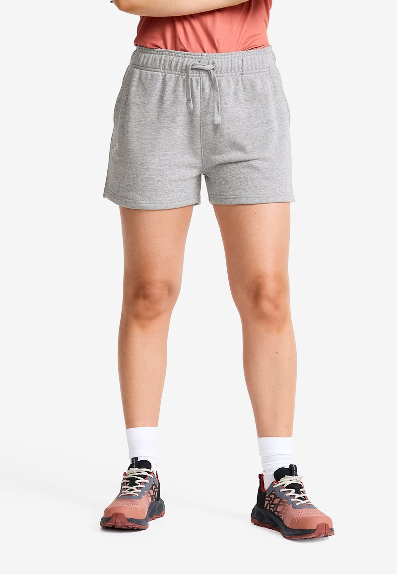 Grå bomullsshorts med elastisk midja och snörning. Designade med sidofickor och avslappnad passform, ihop med flerfärgade träningsskor.