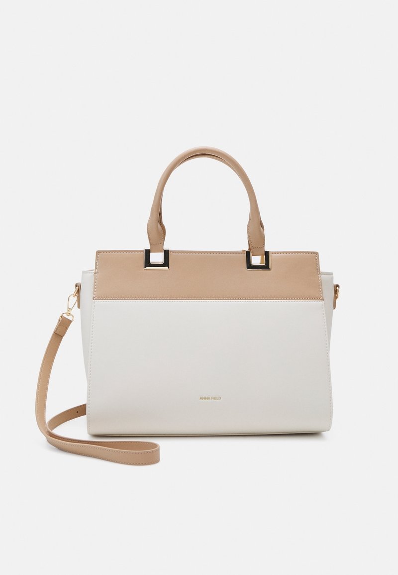 Sac à main rectangulaire beige et blanc avec deux poignées supérieures et une bandoulière détachable, agrémenté d'accents en métal doré.