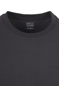 Donkergrijze katoenen t-shirt met een ronde halslijn, ribbelstructuur en subtiele merkvermelding op de borst. Eenvoudig en strak ontwerp zonder patronen.