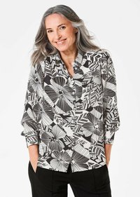 Camicia a maniche lunghe realizzata in tessuto leggero, di colore nero e bianco, con un motivo floreale e geometrico e bottoni lungo la parte anteriore.