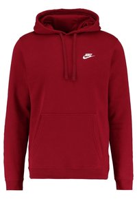 Czerwona bluza Nike z kapturem, posiadająca przednią kieszeń, regulowany kaptur ze sznurkiem oraz biały logo na piersi. Materiał wydaje się miękki i teksturowany.