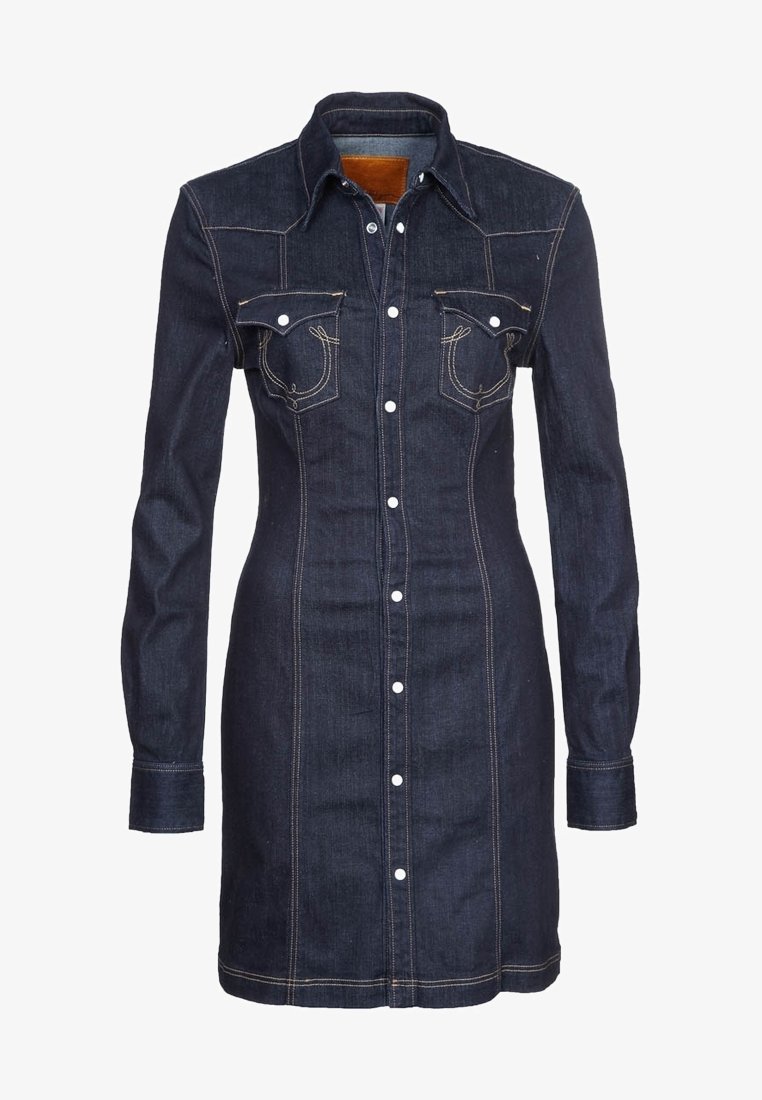 Robe en denim bleu foncé avec manches longues, boutons-pression à l'avant, col pointu et deux poches poitrine à rabat avec détails de couture blanche.