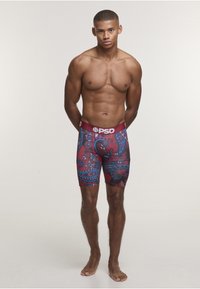 Pánské přiléhavé boxerky s vínovým elastickým pasem. Mají modrý paisley vzor na červeném pozadí. Vyrobené z elastické tkaniny.