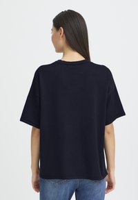 T-shirt oversize bleu marine en tissu doux, avec manches courtes, col rond et coupe décontractée, doté de détails de coutures renforcées.